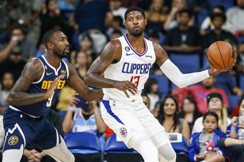 Los Angeles Clippers forward Paul George, right, is defended by Denver Nuggets guard Davon Reed