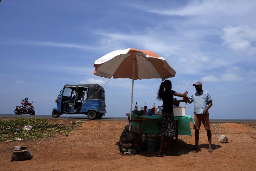 Un hombre compra una bebida refrescante de un vendedor ambulante en un día soleado, el 29 de febrero de 2024, en Mahawewa, un poblado ubicado al norte de Colombo, Sri Lanka. (AP Foto/Eranga Jayawardena, Archivo)