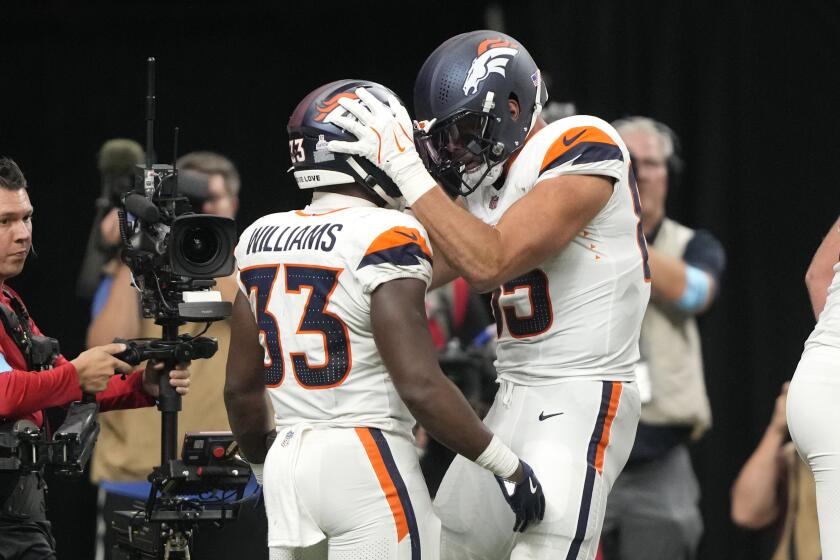 Javonte Williams (33), corredor de los Broncos de Denver, festeja con su compañero Lucas Krull tras anotar ante los Saints de Nueva Orleáns, el jueves 17 de octubre de 2024 (AP Foto/Gerald Herbert)