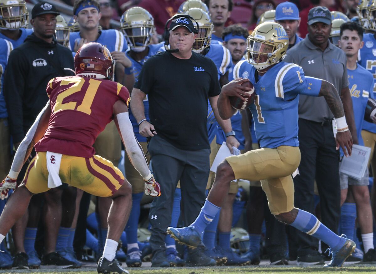UCLA coach Chip Kelly looks on as quarterback Dorian Thompson-Robinson is shoved out of bounds 