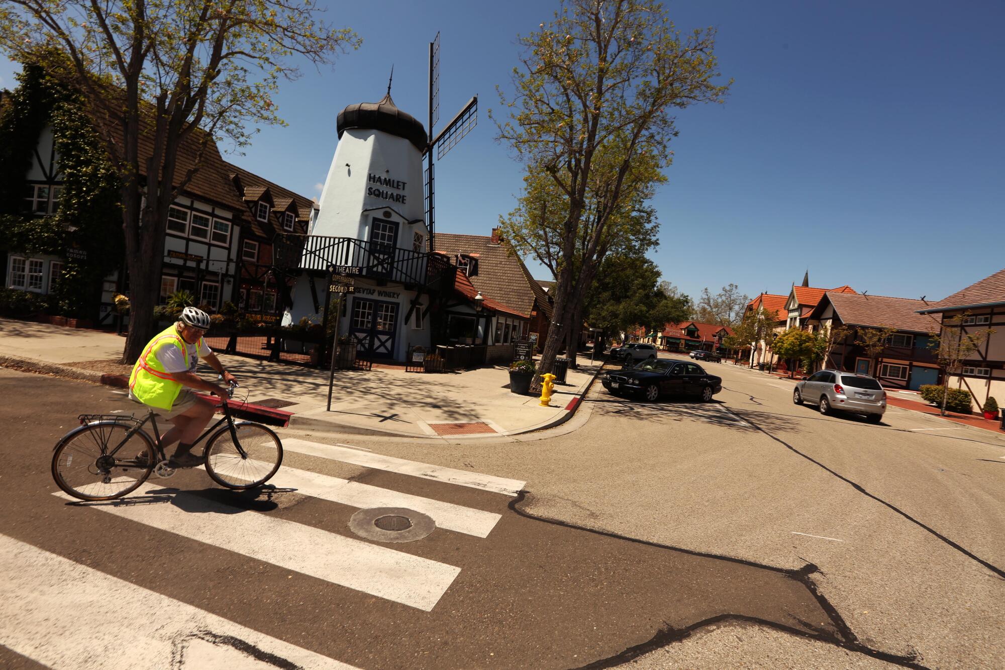 Chuck Stacy, 72, bikes down a street that is usually filled with cars and tourists in downtown Solvang last week.