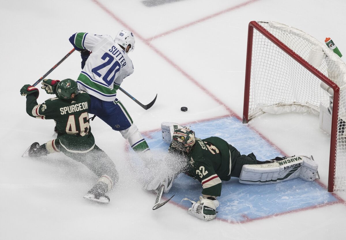 Minnesota Wild goalie Alex Stalock (32) makes the save on Vancouver Canucks' Brandon Sutter (20) as Wild's Jared Spurgeon (46) defends during the third period of an NHL hockey qualifying round game, Friday, Aug. 7, 2020, in Edmonton, Alberta. (Jason Franson/The Canadian Press via AP)