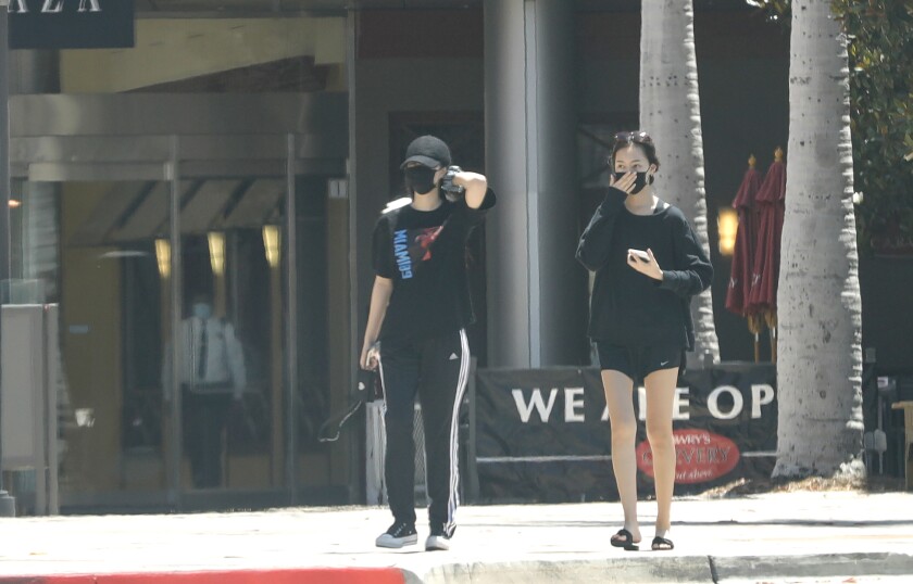 Shoppers exit South Coast Plaza on Tuesday.