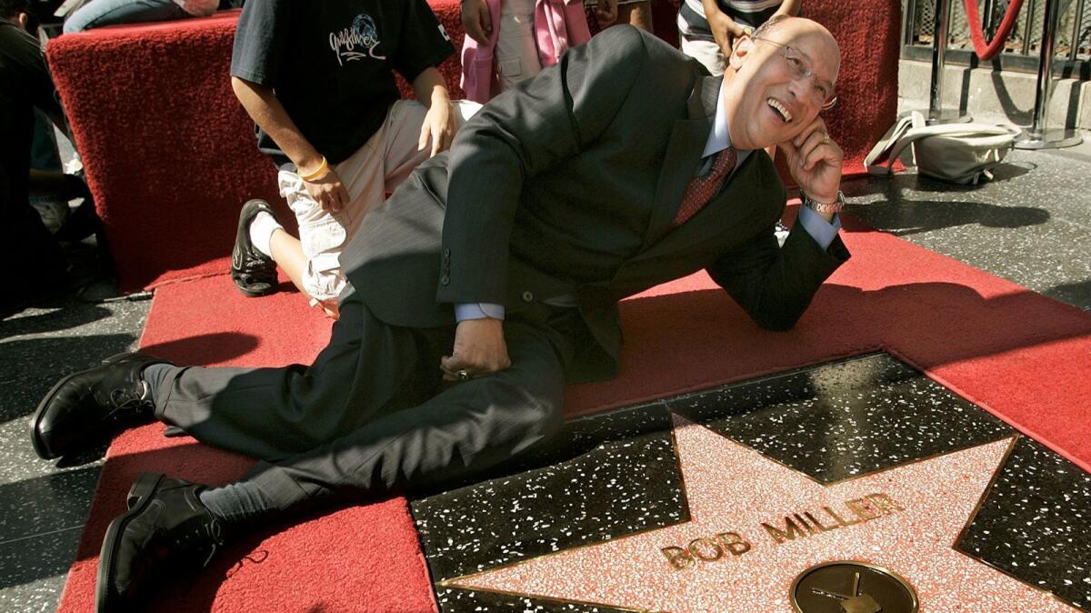 Hockey Hall of Fame announcer Bob Miller lies down next to his star on the Hollywood Walk of Fame on Oct. 2, 2006.