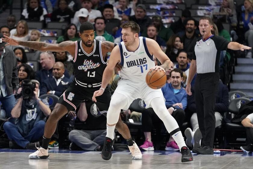 Dallas Mavericks guard Luka Doncic (77) dribbles against Los Angeles Clippers guard Paul George (13) during the first quarter of an NBA basketball game in Dallas, Tuesday, Nov. 15, 2022. (AP Photo/LM Otero)
