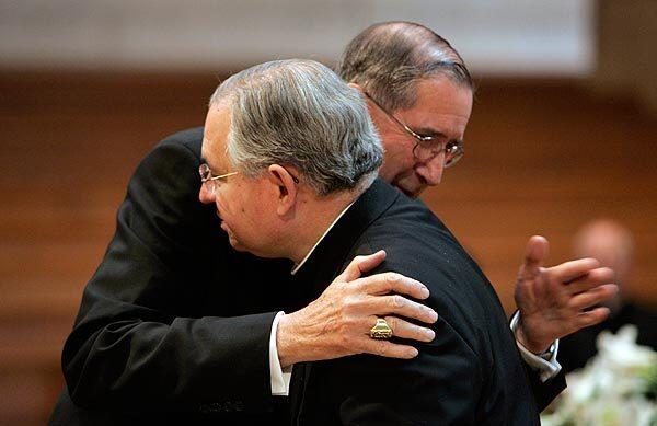 Archbishop Jose Gomez, front, and Cardinal Roger Mahony exchange a hug at the Cathedral of Our Lady of the Angels. See full story