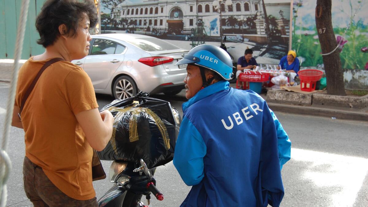 Bike-sharing apps like uberMOTO are replacing street-corner men who for decades offered cheap motorcycle trips. (L.R. Meyers)