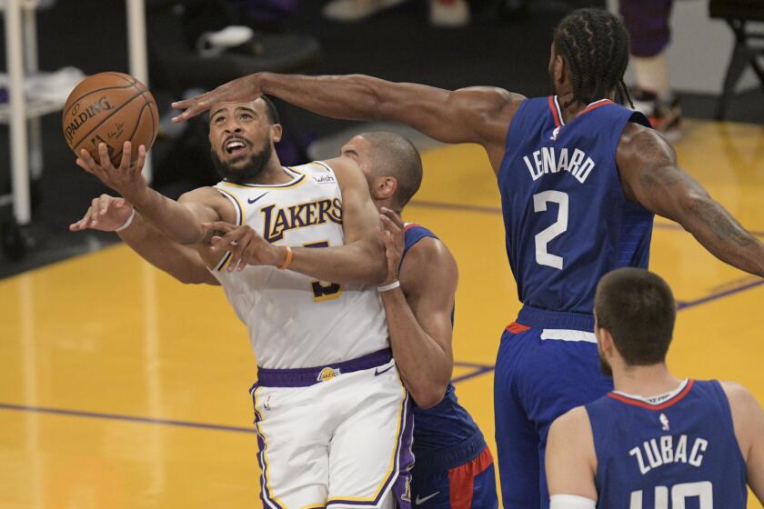 Los Angeles Lakers guard Talen Horton-Tucker, left, draws a foul as he shoots under pressure.