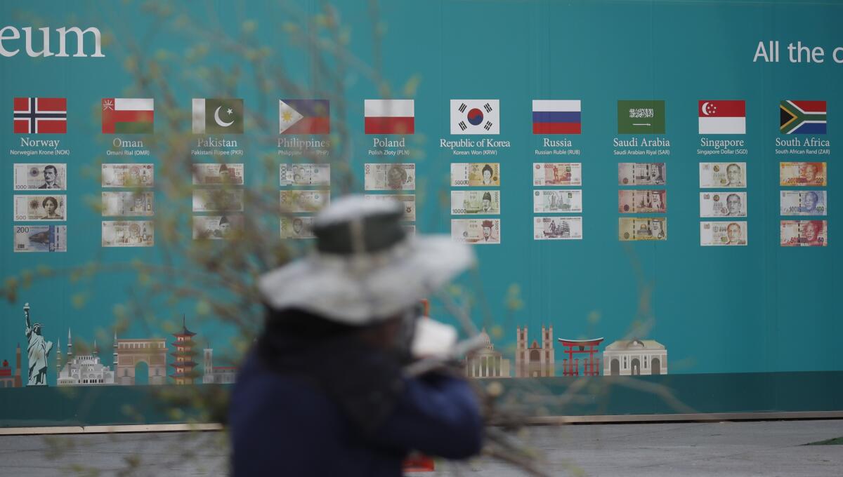 A worker walks past a bank's advertisement in Seoul on March 24.