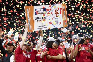 USC freshman JuJu Watkins embraces a teammate as the Trojans celebrate winning the Pac-12 tournament title 