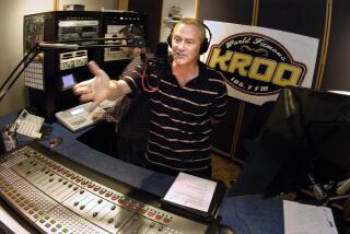 Friday May 16, 2003-Kevin Ryder from KROQ's Kevin and Bean morning show, gestures to his partner Gene Bean who is on the television screen in the corner of the studio during a live broadcast from KROQ's studio on Venice Blvd. in Los Angeles. Bean broadcasts his part of the show via satellite from Seattle, Washington. Bean and Ryder can see each other during their broadcasts as each has a camera pointed at them with a monitor nearby to see each other. (Jamie Rector/For The Times)