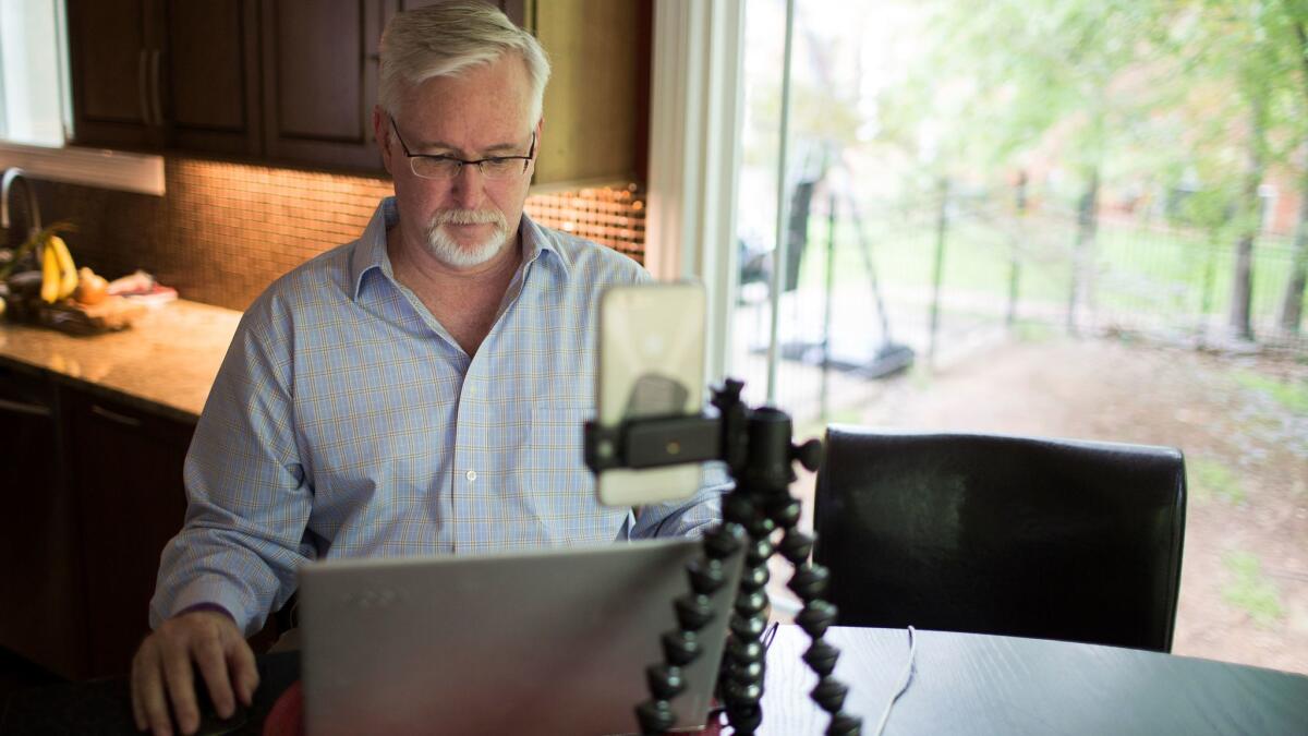 Brian Kursonis browses on his computer at his kitchen table where he runs his website, WithALZmyheart.com. Kursonis was diagnosed with early onset Alzheimer's disease at the age of 55.