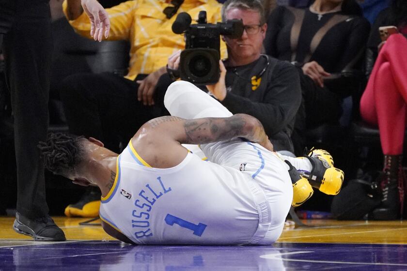 Los Angeles Lakers guard D'Angelo Russell writhes on the floor after injuring his ankle during the first half of an NBA basketball game against the Golden State Warriors Thursday, Feb. 23, 2023, in Los Angeles. (AP Photo/Mark J. Terrill)