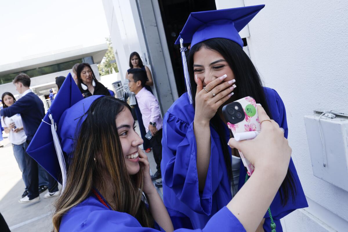 Itati Pelayo, left, and Daisy Lopez make a TikTok post before the Palisades High graduation ceremony.