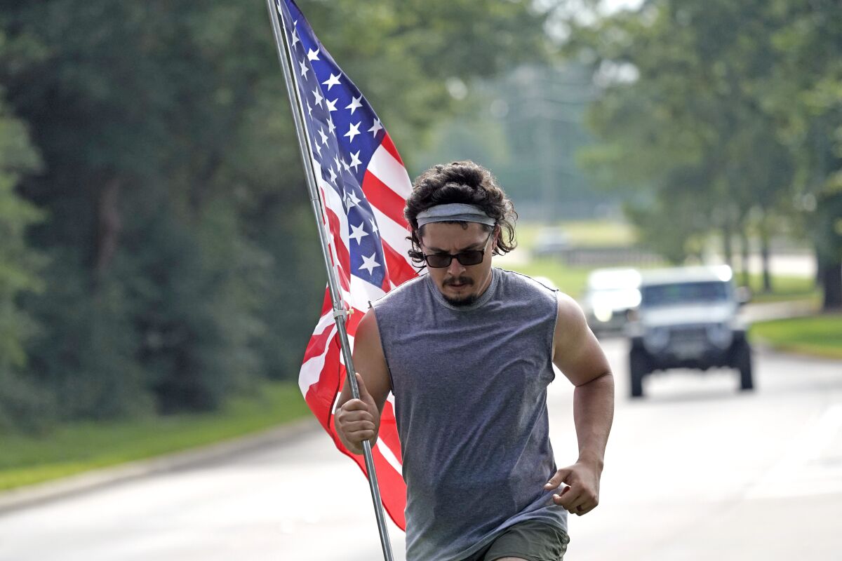 A man jogs along a Houston road with an American flag on Saturday.