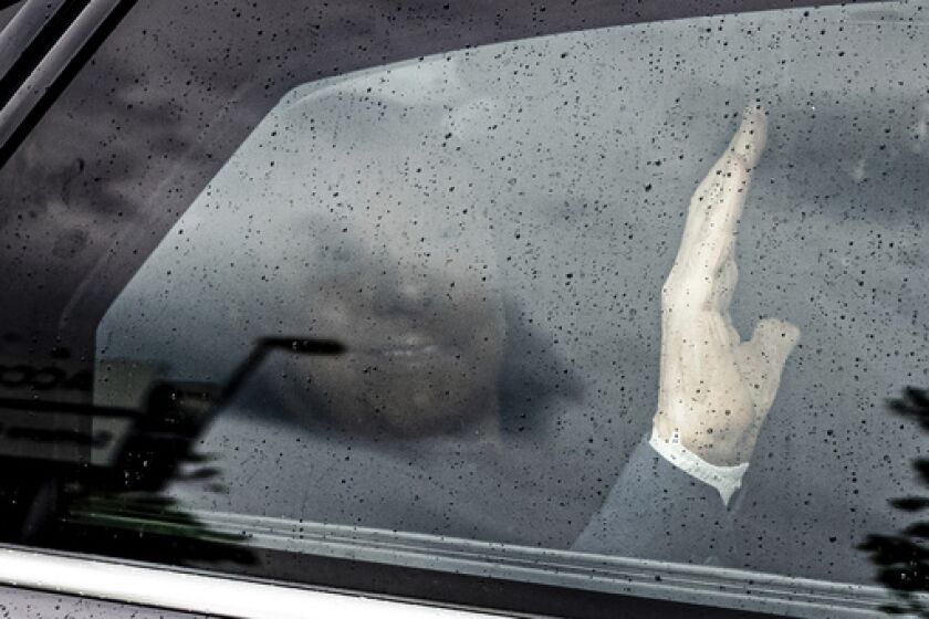 Silvio Berlusconi waves as his car speeds past photographers and reporters without stopping to make remarks as he leaves the San Raffaele hospital, in Milan, Italy, Friday, May 19, 2023. Former Italian Premier Silvio Berlusconi has been released from a Milan hospital, a month and a half after he was admitted with a lung infection. (Alessandro Bremec/LaPresse via AP)