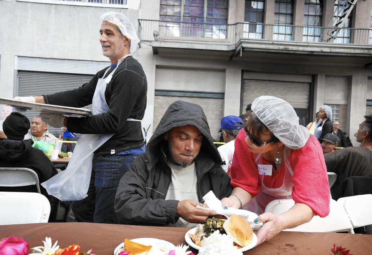Gail Modyman serves Hector Diaz during the annual Midnight Mission Thanksgiving brunch on skid row.