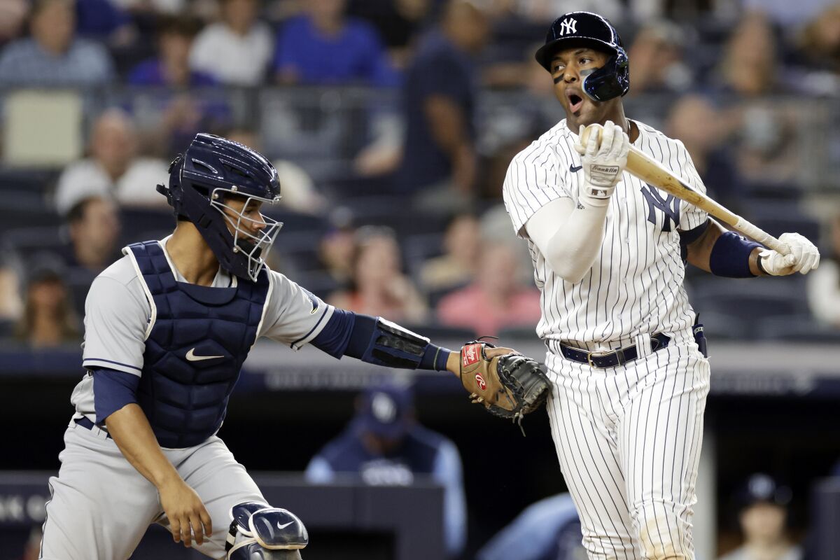 New York Yankees designated hitter Miguel Andujar reacts after striking out then being tagged by Tampa Bay Rays catcher Francisco Mejia during the sixth inning of a baseball game Monday, Aug. 15, 2022, in New York. (AP Photo/Adam Hunger)
