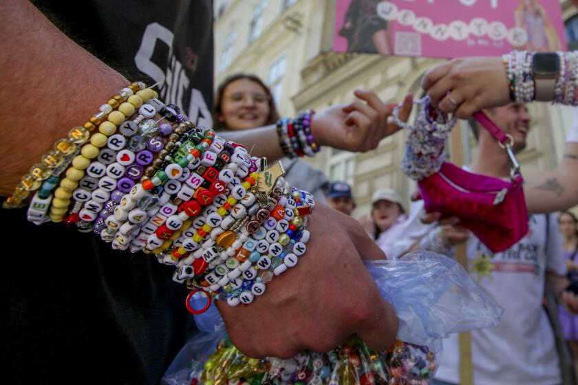 Swifties intercambian pulseras en el centro de Viena el jueves 8 de agosto de 2024. (AP Foto/Heinz-Peter Bader)