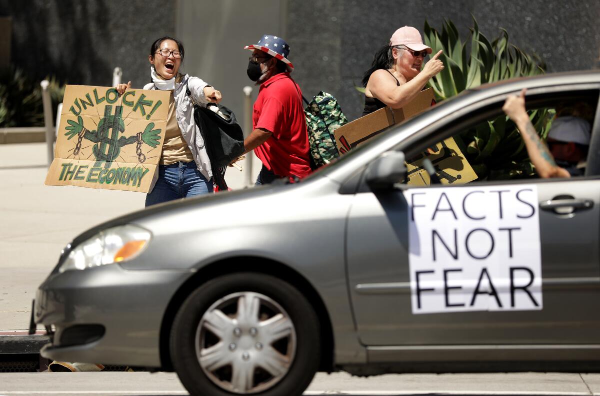 Maya Cruz and other protesters call for the reopening of the California economy in downtown Los Angeles on Wednesday.