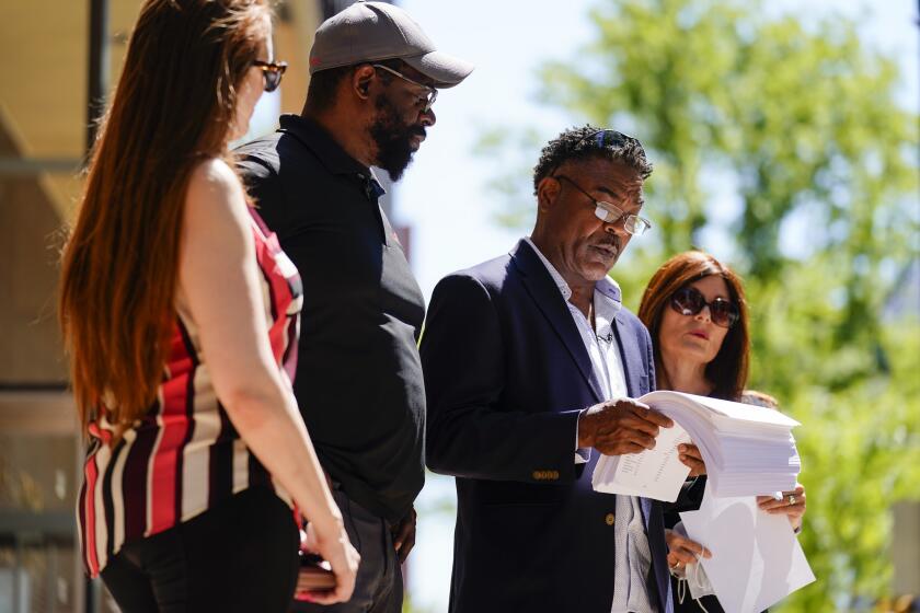 From left, Brooke Vaughn, her husband former NFL player Clarence Vaughn III, former NFL player Ken Jenkins and his wife Amy Lewis read a letter before delivering tens of thousands of petitions demanding equal treatment for everyone involved in the settlement of concussion claims against the NFL, to the federal courthouse in Philadelphia, Friday, May 14, 2021. (AP Photo/Matt Rourke)