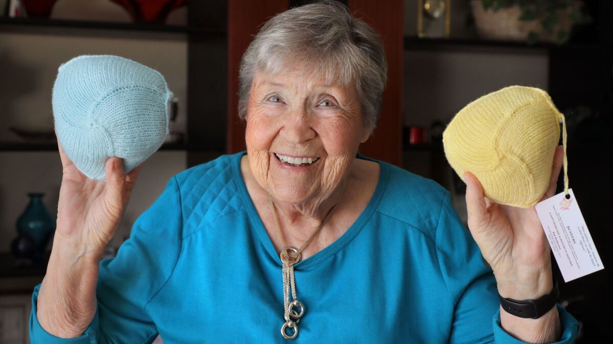 Pat Anderson, 86, of Escondido holds two of her "Busters" wardrobe accessories she knitted for breast cancer survivors who've had mastectomies.