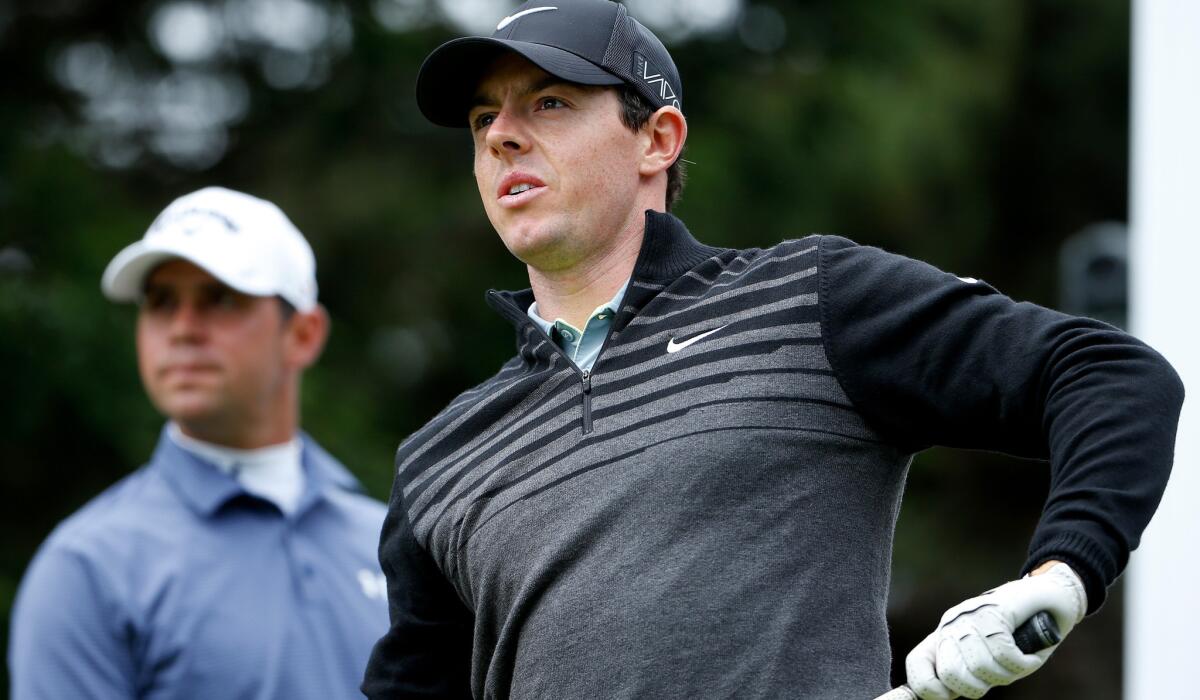 Rory McIlroy and opponent Gary Woodland watch his tee shot at the ninth hole during the Match Play Championship final on Sunday at TPC Harding Park.