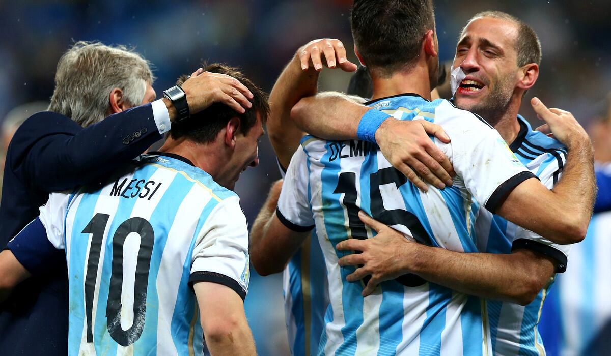 Argentina teammates Lionel Messi (10), Martin Demichelis (15) and Pablo Zabaleta celebrate after defeating the Netherlands on penalty kicks, 4-2, in a World Cup semifinal on Wednesday at Arena Corinthians in Sao Paulo, Brazil.
