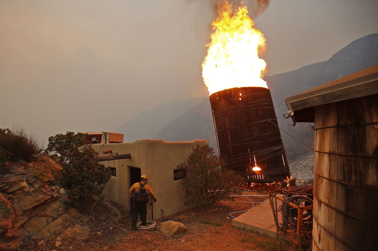 Josh Acosta, superintendent with Fulton Hotshots looks for ways to fight fire consuming a structure threatening two homes high up Toro Canyon in Carpenteria at dusk Tuesday.