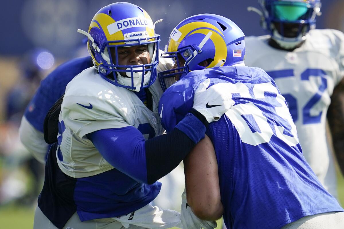 Rams defensive tackle Aaron Donald, left, tries to get around a block by center Austin Corbett during practice