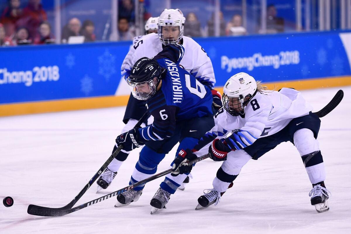 Finland's Jenni Hiirikoski, left, and the United States' Emily Pfalzer fight for the puck.