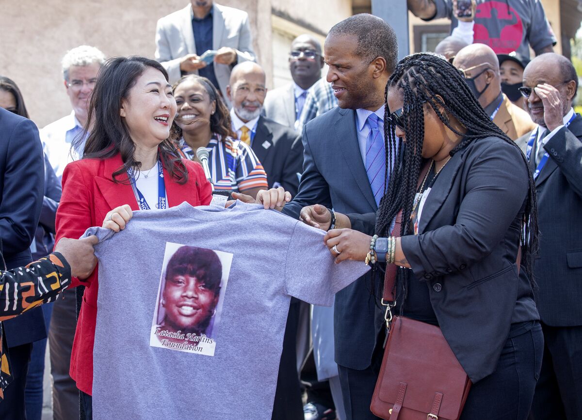 Hyepin Im, President and Founder of Faith and Community Empowerment, receives a shirt with an image of Latasha Harlins.