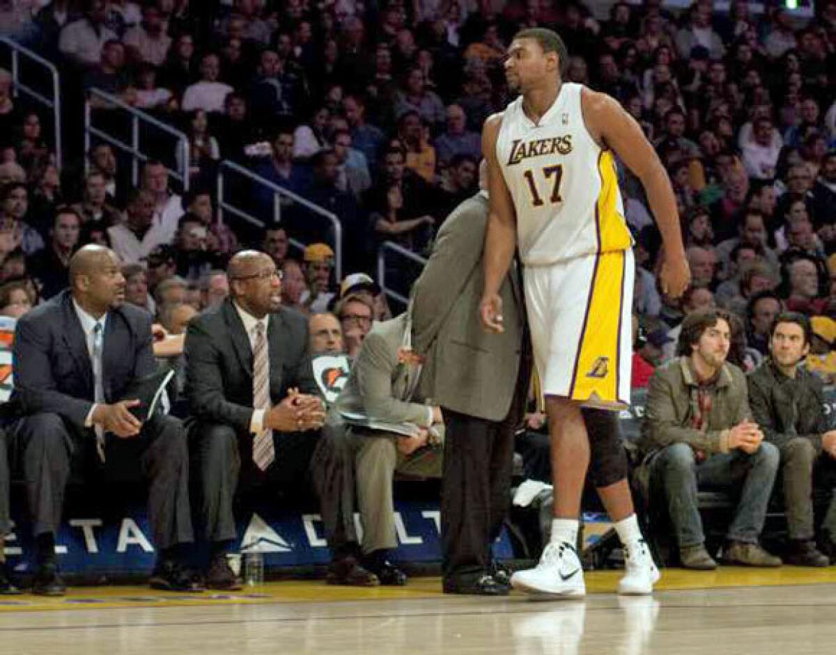 Andrew Bynum limps to the bench after injuring his ankle.