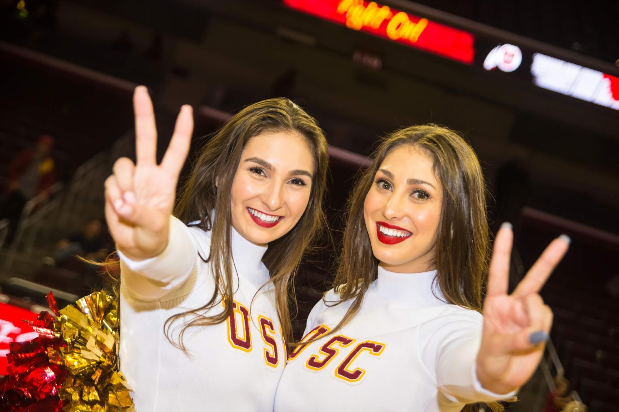 Song Girls Bella, left, and Adrianna Robakowski flash victory signs.