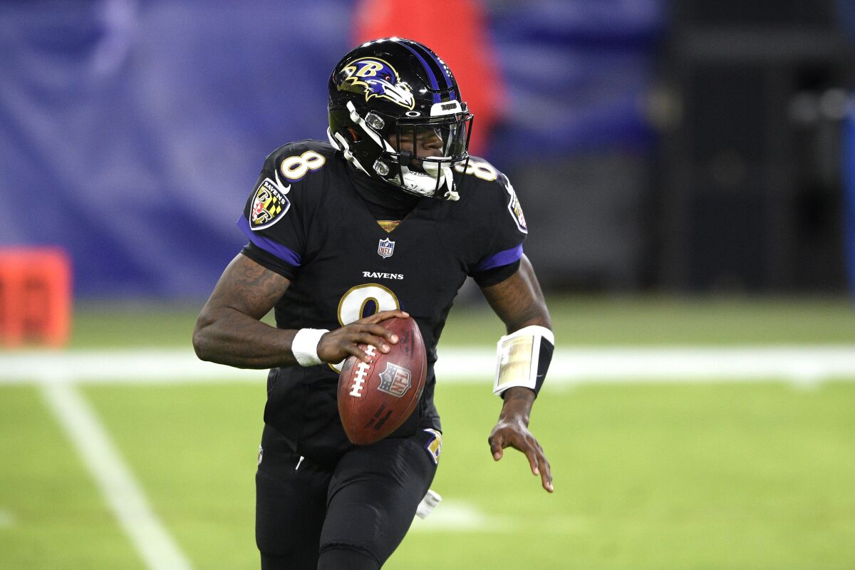 Baltimore Ravens quarterback Lamar Jackson rolls out against the Dallas Cowboys during the first half of an NFL football game, Tuesday, Dec. 8, 2020, in Baltimore. (AP Photo/Nick Wass)