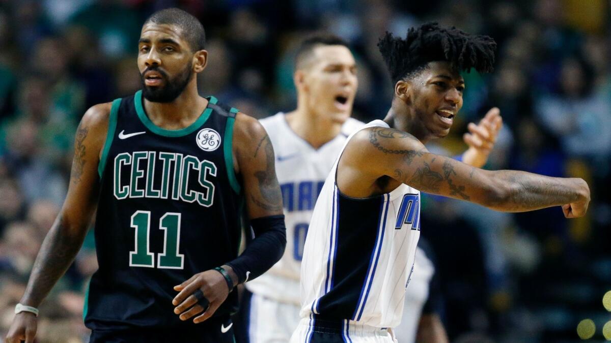 Orlando Magic's Elfrid Payton, right, and Aaron Gordon, behind, protest a call beside Boston Celtics' Kyrie Irving (11) during the first quarter.