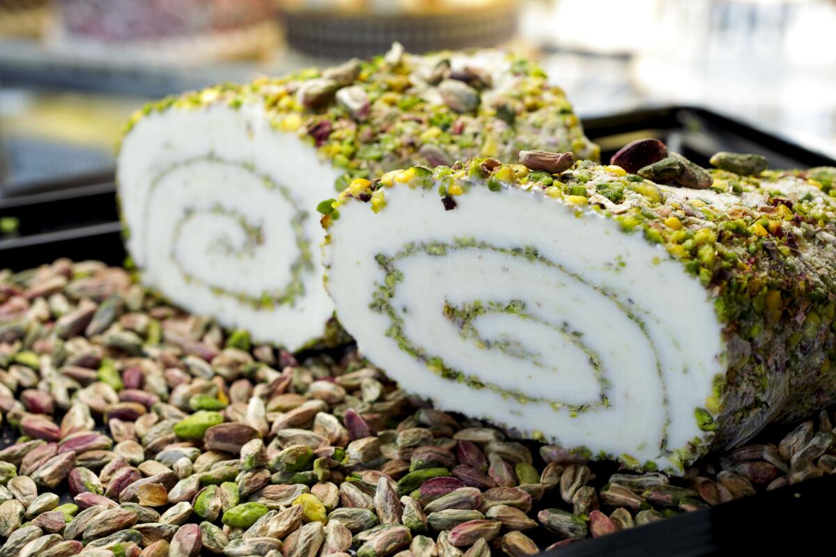 white ice cream rolled up in logs with pistachios