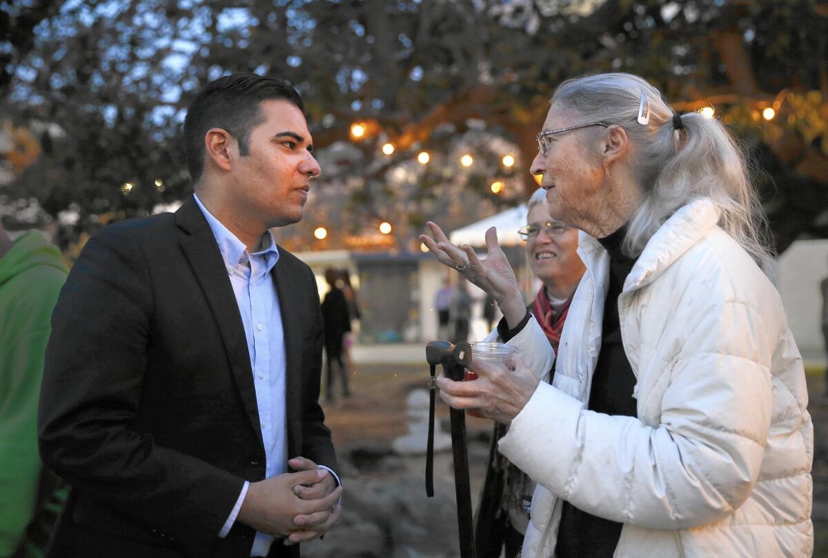 Long Beach Mayor Robert Garcia talks to a guest before speaking about the city's downtown accomplishments in Lincoln Park.