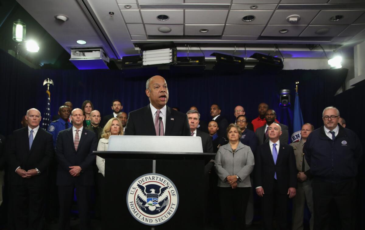 Secretary of Homeland Security Jeh Johnson speaks at a news conference as department employees listen. He said 75% to 80% of his agency's workforce would have to come to work without pay if Congress doesn't fund the department.