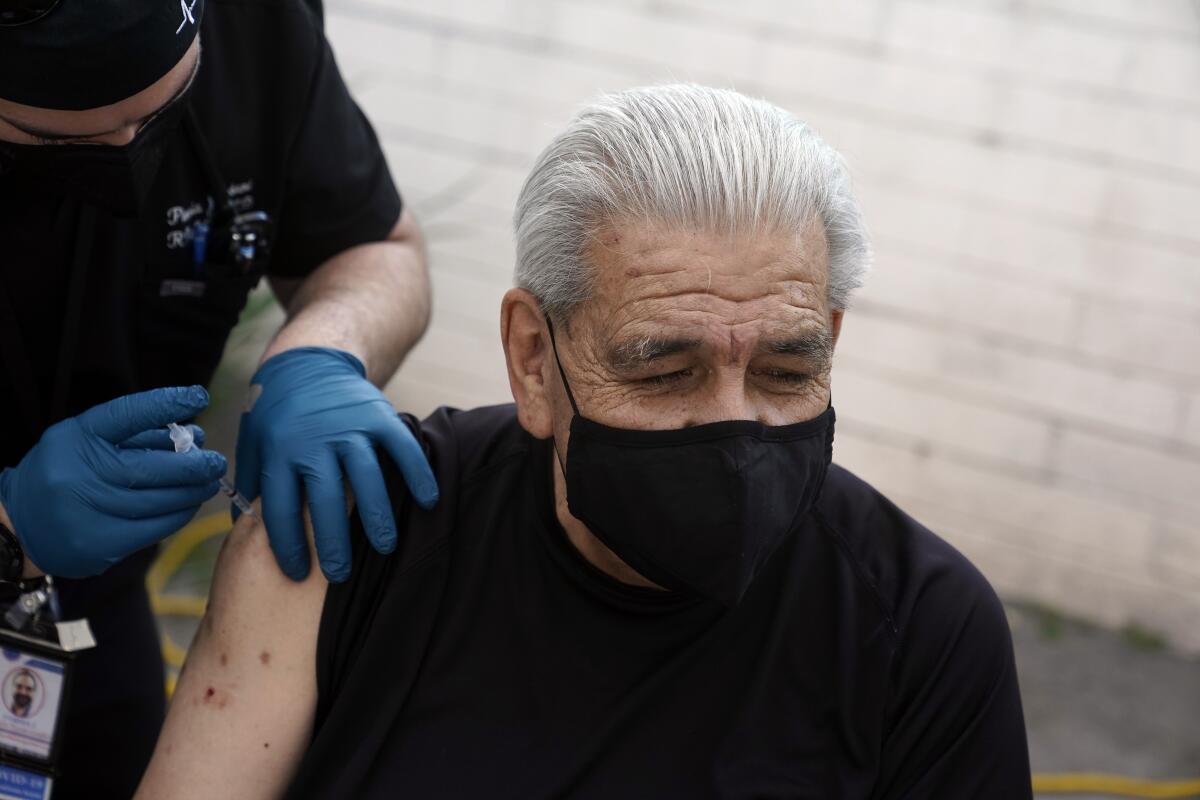 Edward Muro gets a shot of Pfizer's COVID-19 vaccine at Families Together of Orange County Community Health Center, Friday, Feb. 26, 2021, in Tustin, Calif. (AP Photo/Marcio Jose Sanchez)