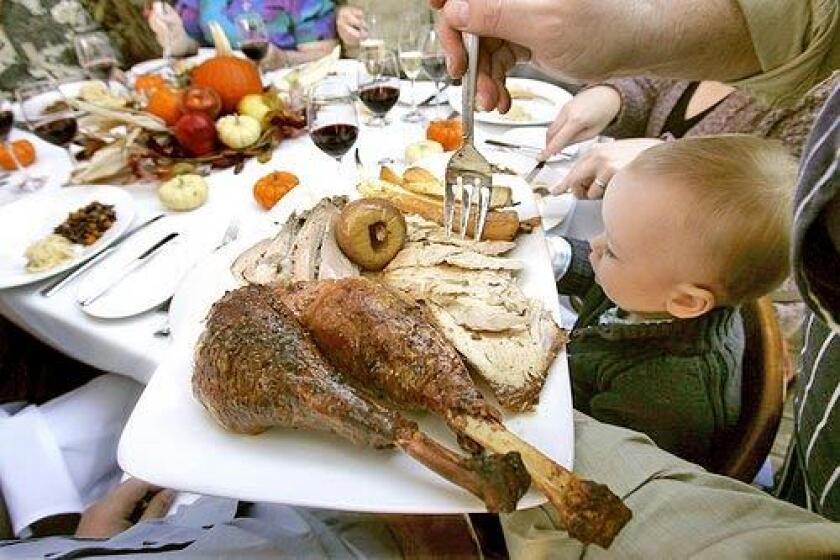 Chef Christian Shaffer serves his Heritage turkey with blistered pears and parsnips to relatives gathered around the Thanksgiving table at the home of his cousin, Mitchell Sonners. At right is his nephew, Dylan Shaffer, 17 months.