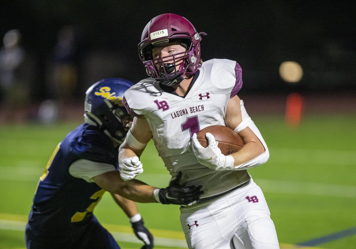 Laguna Beach's Nick Rogers breaks a tackle by a Crean Lutheran defender during a game on Friday.