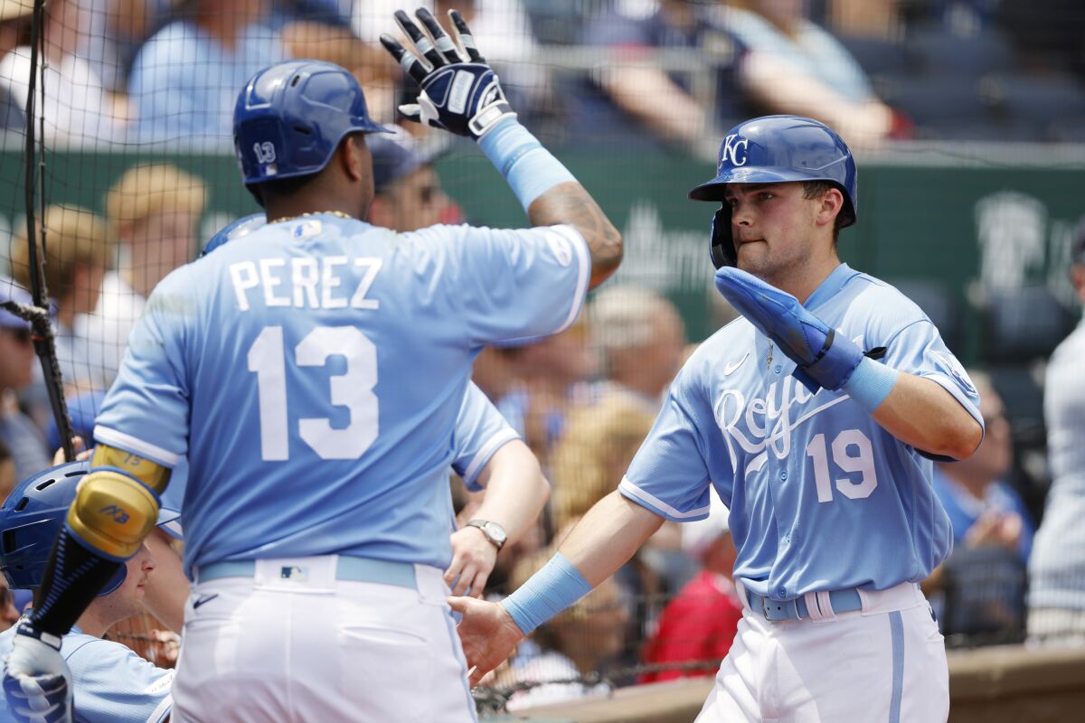 Kansas City Royals' Salvador Perez (13) congratulates Michael Massey (19) after Massey scored on a balk by Boston Red Sox pitcher Kutter Crawford during the third inning of a baseball game in Kansas City, Mo., Sunday, Aug. 7, 2022. (AP Photo/Colin E. Braley)