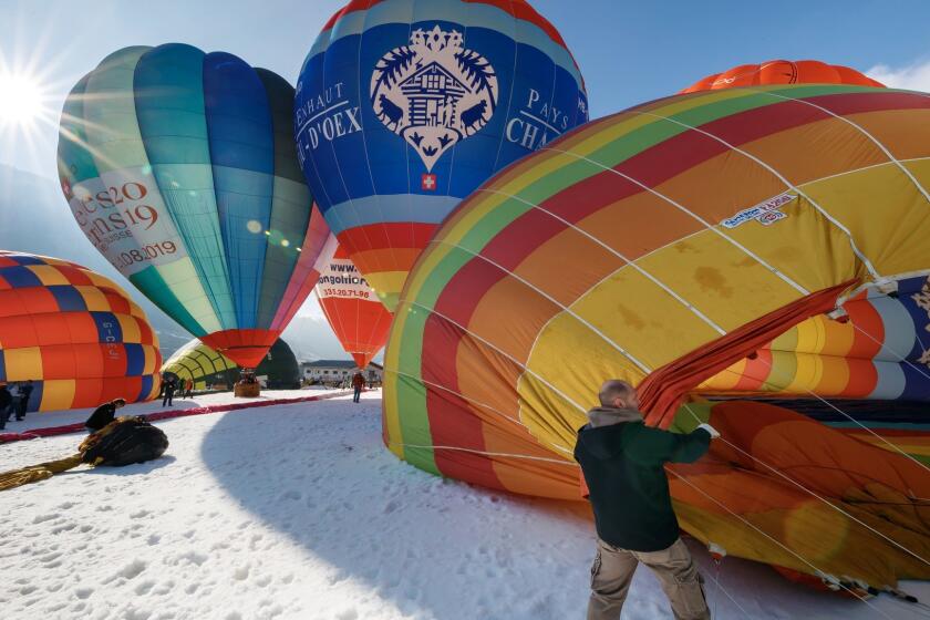Hot air balloons are inflated prior to take off during the 40th International Hot Air Balloon week, in the skiing resort of Chateau d'Oex, Switzerland, Saturday, Jan. 27, 2018. (Valentin Flauraud/Keystone via AP)