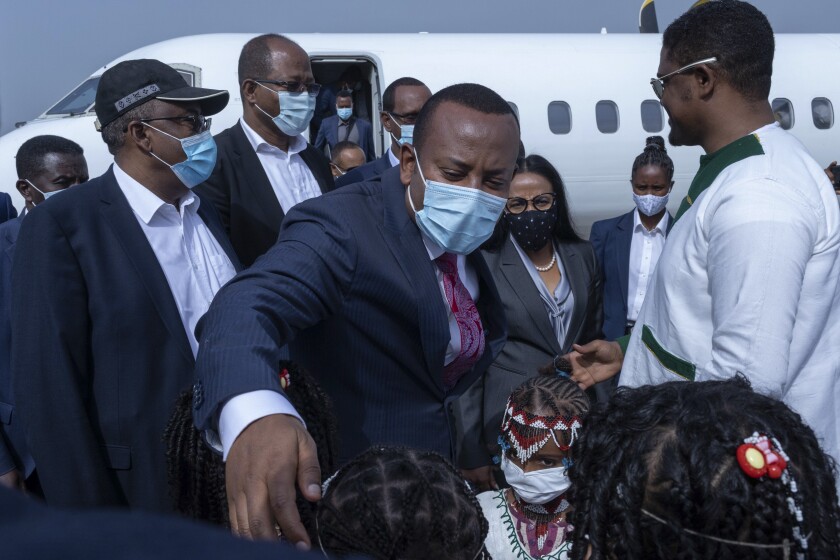 Children greet Ethiopia's Prime Minister Abiy Ahmed and his entourage at an airport
