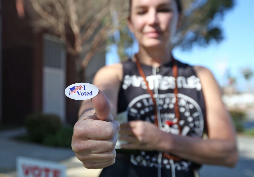 Sarah Stockstill, 48, an artist who recently moved to Costa Mesa, proudly shows her "I voted" sticker after casting her ballot at the Costa Mesa Senior Center in Tuesday's primary election.