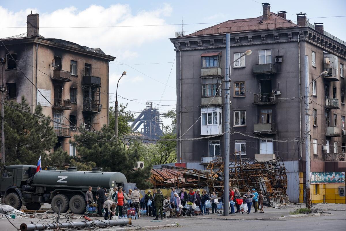 People lining up for water from a water truck