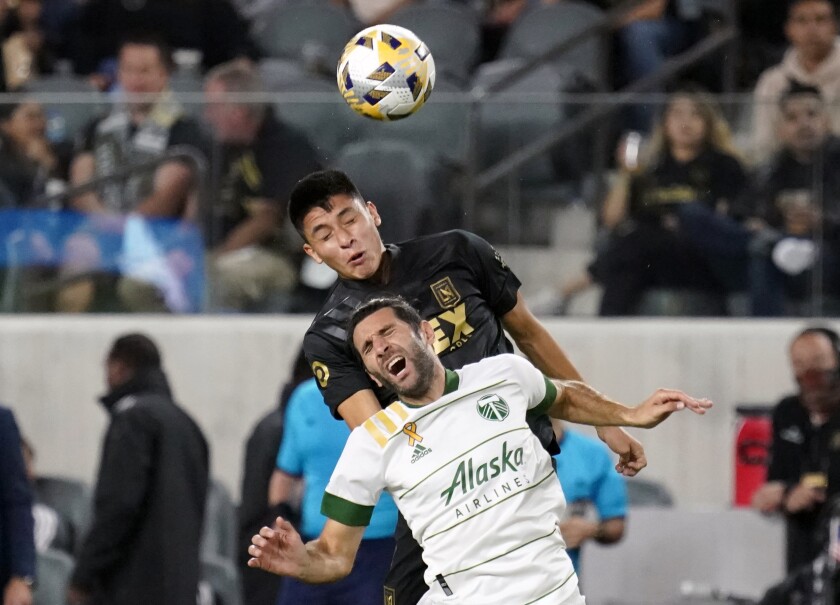 Portland Timbers midfielder Diego Valeri is defended by LAFC defender Marco Farfan.