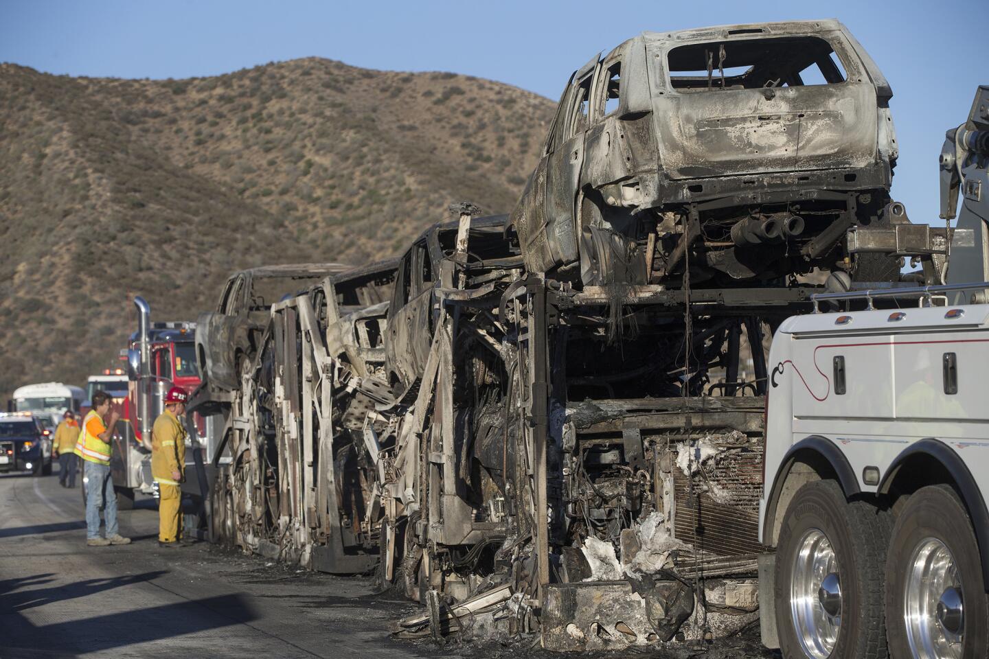 Burned cars sit on a car carrier after a brush fire jumped the 15 Freeway in the Cajon Pass.