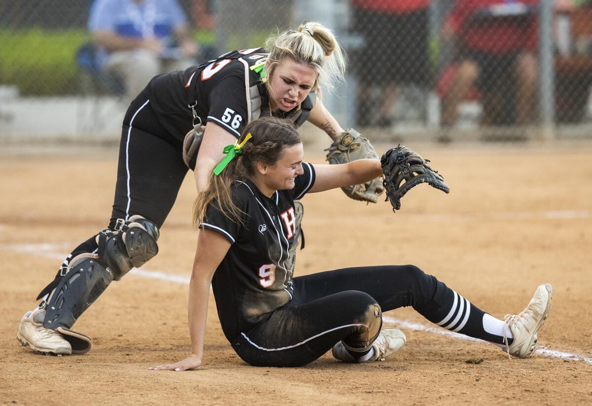 Huntington Beach's Rachael Arnold, left, congratulates Grace Grundstrom after she made a diving catch against Los Alamitos.